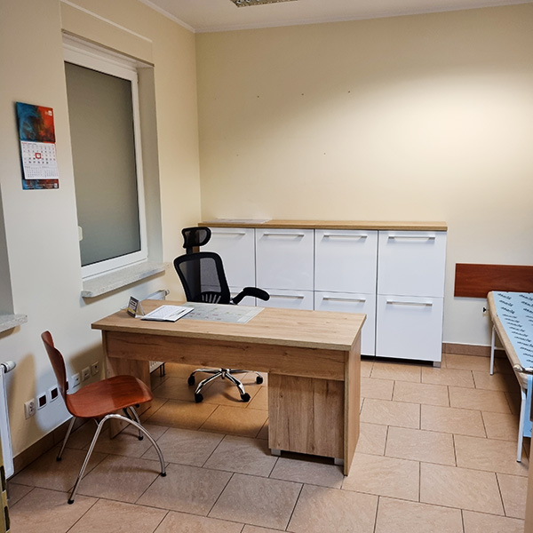 Gabinet Alkomedica w Gorzowie Wielkopolskim. Krzesłko dla pacjenta, biurko, szafka, okno oraz łóżko zabiegowe.
